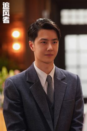 A waist up photograph of Wang Yibo appearing as Wei Ruolai, smiling, wearing a grey, tailored three piece suit.